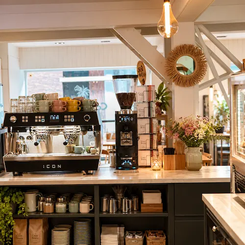 De koffiebar van Cozy Beans met espressomachine en bloemen